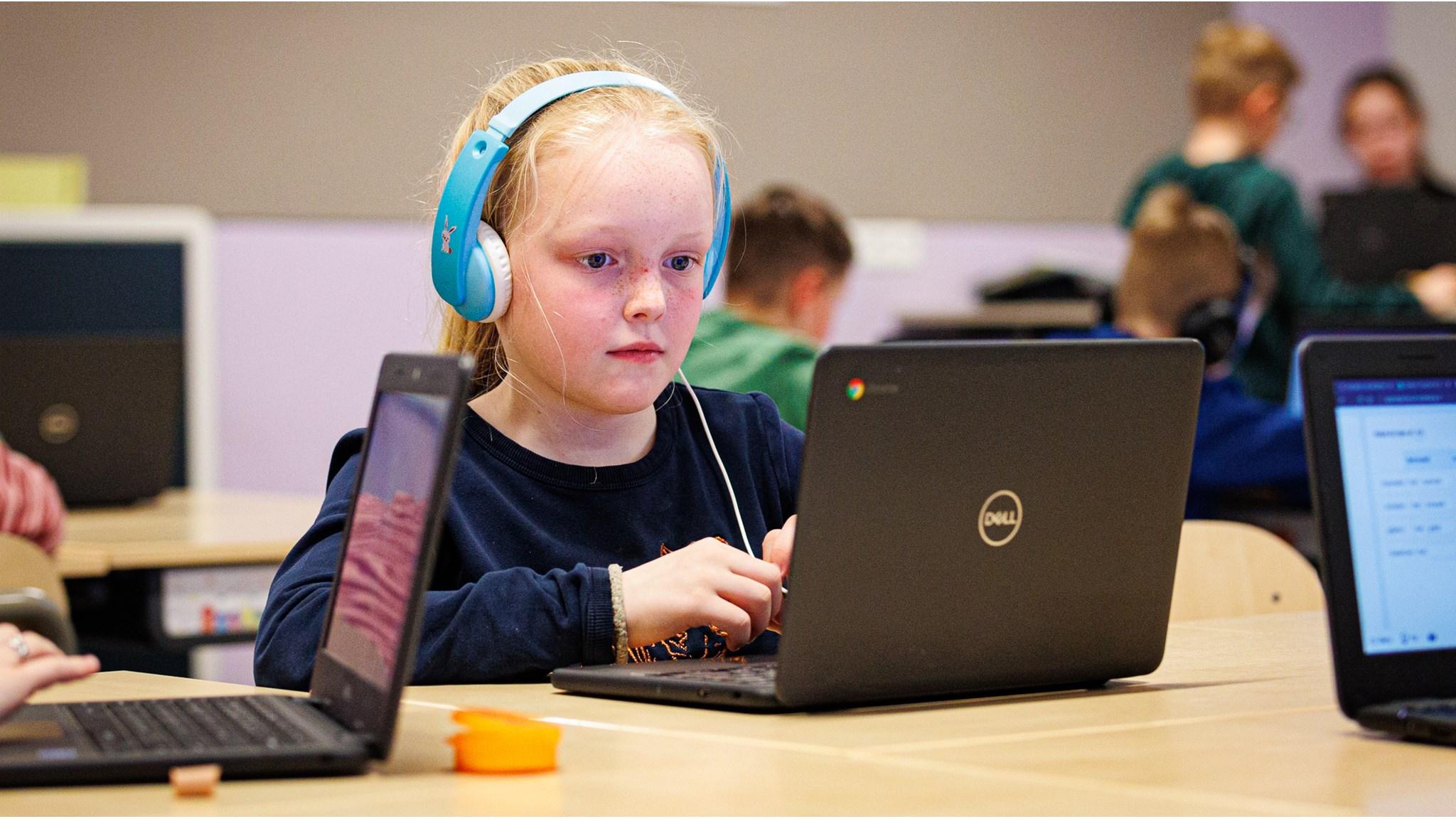 Een leerling van basisschool Sint Jozef in Lithoijen werkt geconcentreerd op een laptop met koptelefoon. Een leerling van basisschool Sint Jozef in Lithoijen werkt geconcentreerd op een laptop met koptelefoon.