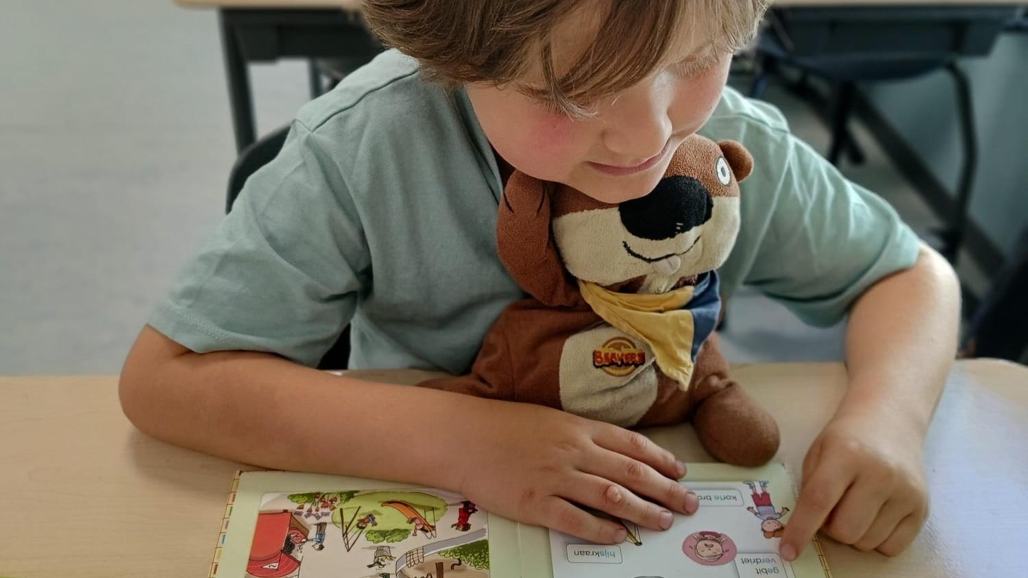 Een leerling van Christelijke Basisschool De Veenbrug in Daarlerveen leest met een knuffeldier op zijn schoot. Een leerling van Christelijke Basisschool De Veenbrug in Daarlerveen leest met een knuffeldier op zijn schoot.