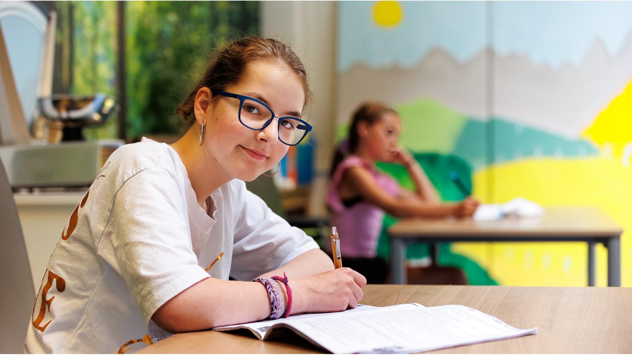 Een leerling van de Antoniusschool in Wijchen schrijft in de klas. Een leerling van de Antoniusschool in Wijchen schrijft in de klas.
