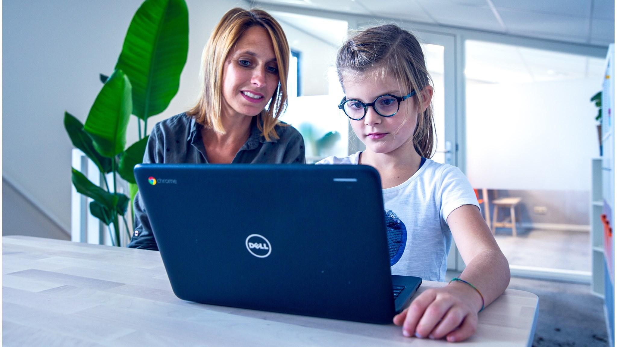 Een leerling van de Christelijke Basisschool de Wegwijzer in 's-Gravenzande werkt samen met een volwassene op een laptop. Een leerling van de Christelijke Basisschool de Wegwijzer in 's-Gravenzande werkt samen met een volwassene op een laptop.