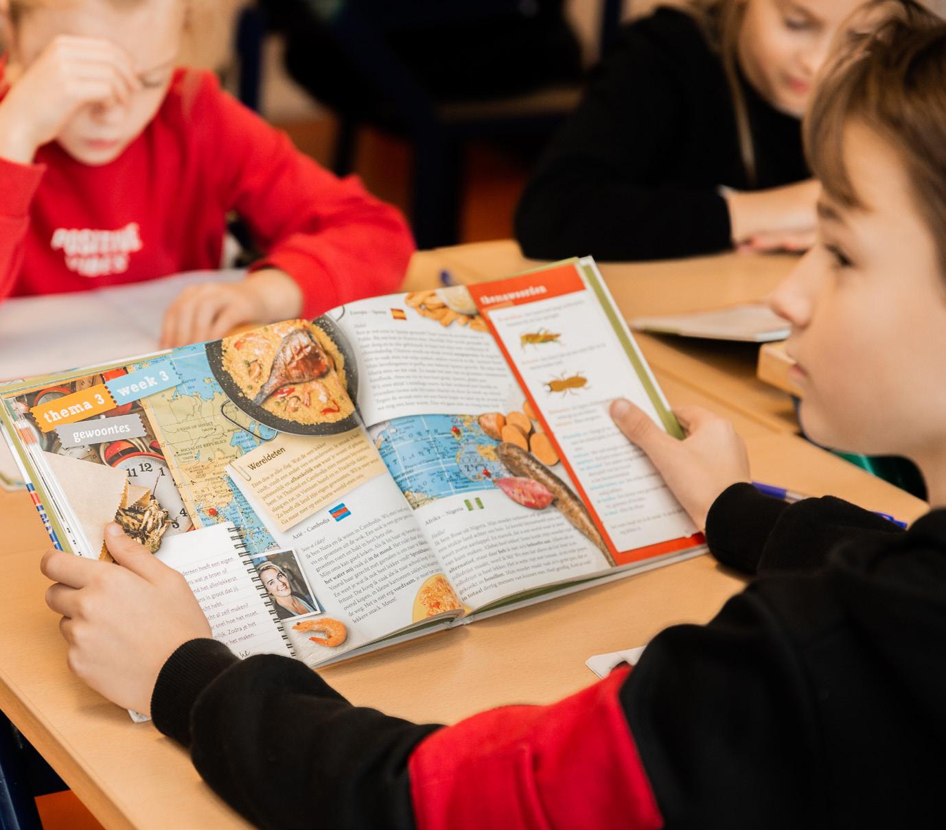 Een leerling van de Paasbergschool in Ede kijkt aandachtig naar een boek tijdens de les.