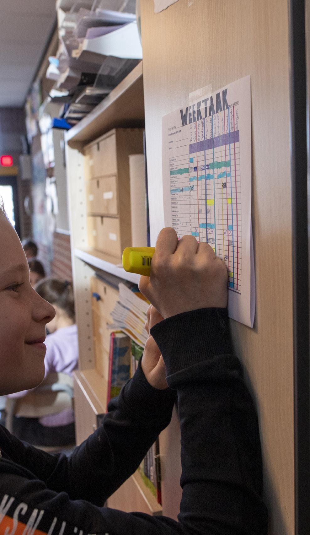 Een leerling van de rooms-katholieke basisschool Sinte Lucij in Steensel markeert het weekplan aan de muur. Een leerling van de rooms-katholieke basisschool Sinte Lucij in Steensel markeert het weekplan aan de muur.