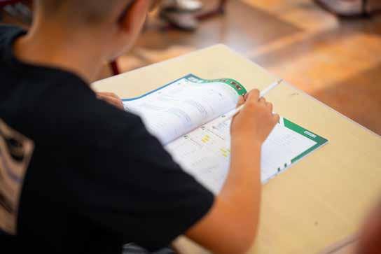 Een leerling van de Van Lingenschool in Zetten maakt aantekeningen in een schoolboek. Een leerling van de Van Lingenschool in Zetten maakt aantekeningen in een schoolboek.