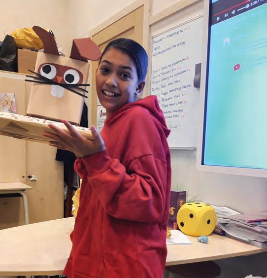 Een leerling van De Vlierboom in Den Haag poseert blij met een zelfgemaakt kunstproject in de klas. Een leerling van De Vlierboom in Den Haag poseert blij met een zelfgemaakt kunstproject in de klas.
