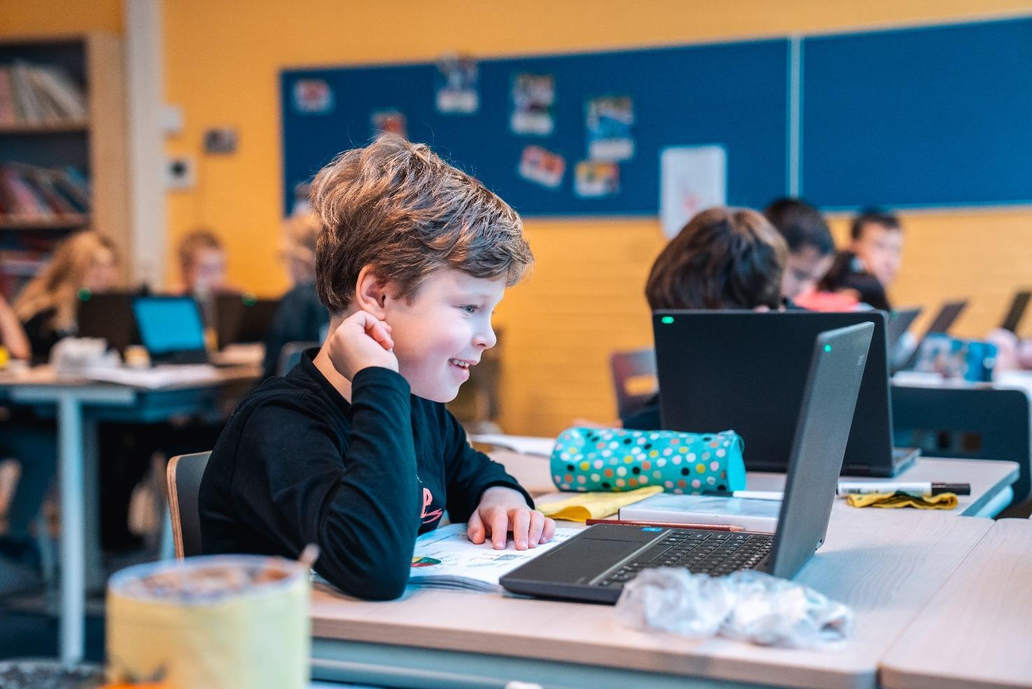 Een leerling van IKC Bernadette Maria in Delft werkt met enthousiasme aan een laptop in de klas. Een leerling van IKC Bernadette Maria in Delft werkt met enthousiasme aan een laptop in de klas.