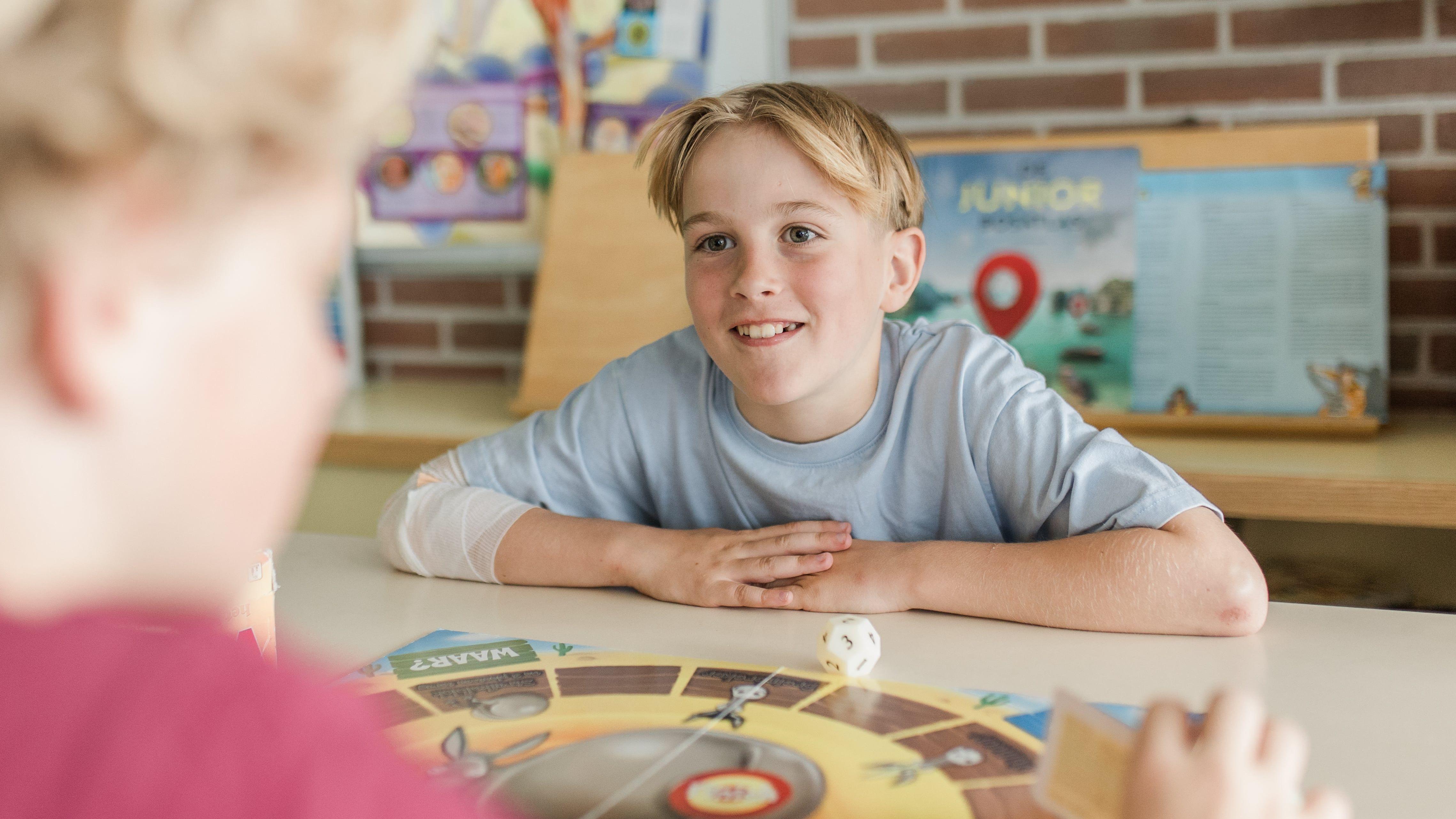 Een leerling van IKC Sint Paulus in Leeuwarden speelt een bordspel met een glimlach. Een leerling van IKC Sint Paulus in Leeuwarden speelt een bordspel met een glimlach.