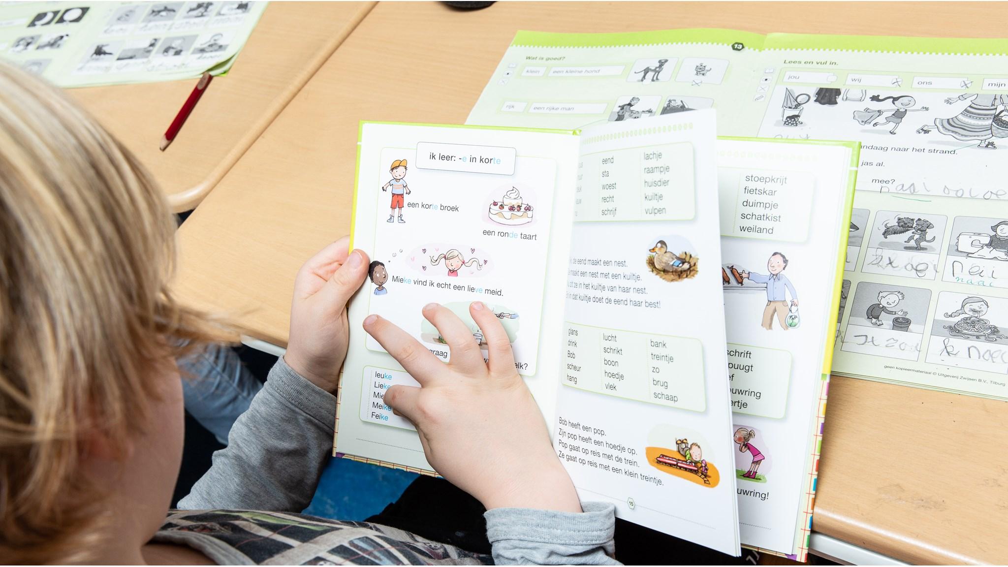 Een leerling van IKC Wynwizer in Leeuwarden kijkt naar een boek met onderwijsactiviteiten. Een leerling van IKC Wynwizer in Leeuwarden kijkt naar een boek met onderwijsactiviteiten.