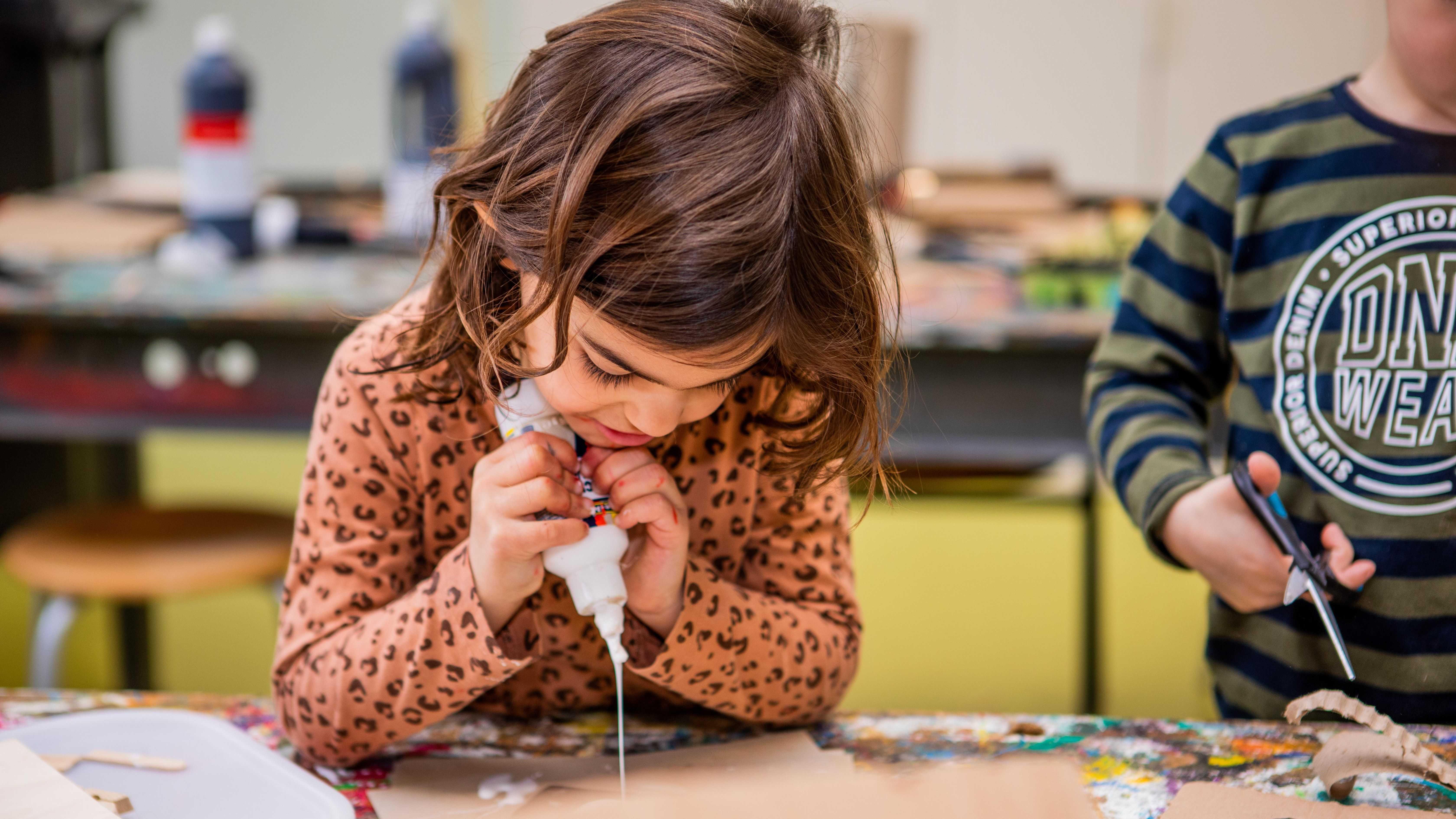 Een leerling van Kids College in Wilnis is bezig met knutselen met lijm. Een leerling van Kids College in Wilnis is bezig met knutselen met lijm.