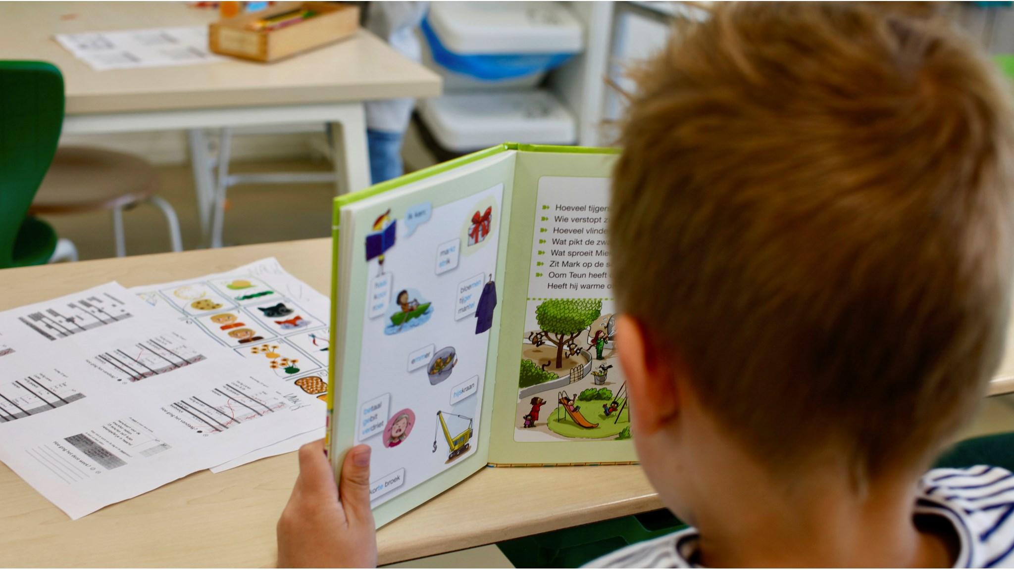 Een leerling van OBS 'Het Tweespan', locatie Schelluinen, leest in een boek op de schoolbank. Een leerling van OBS 'Het Tweespan', locatie Schelluinen, leest in een boek op de schoolbank.