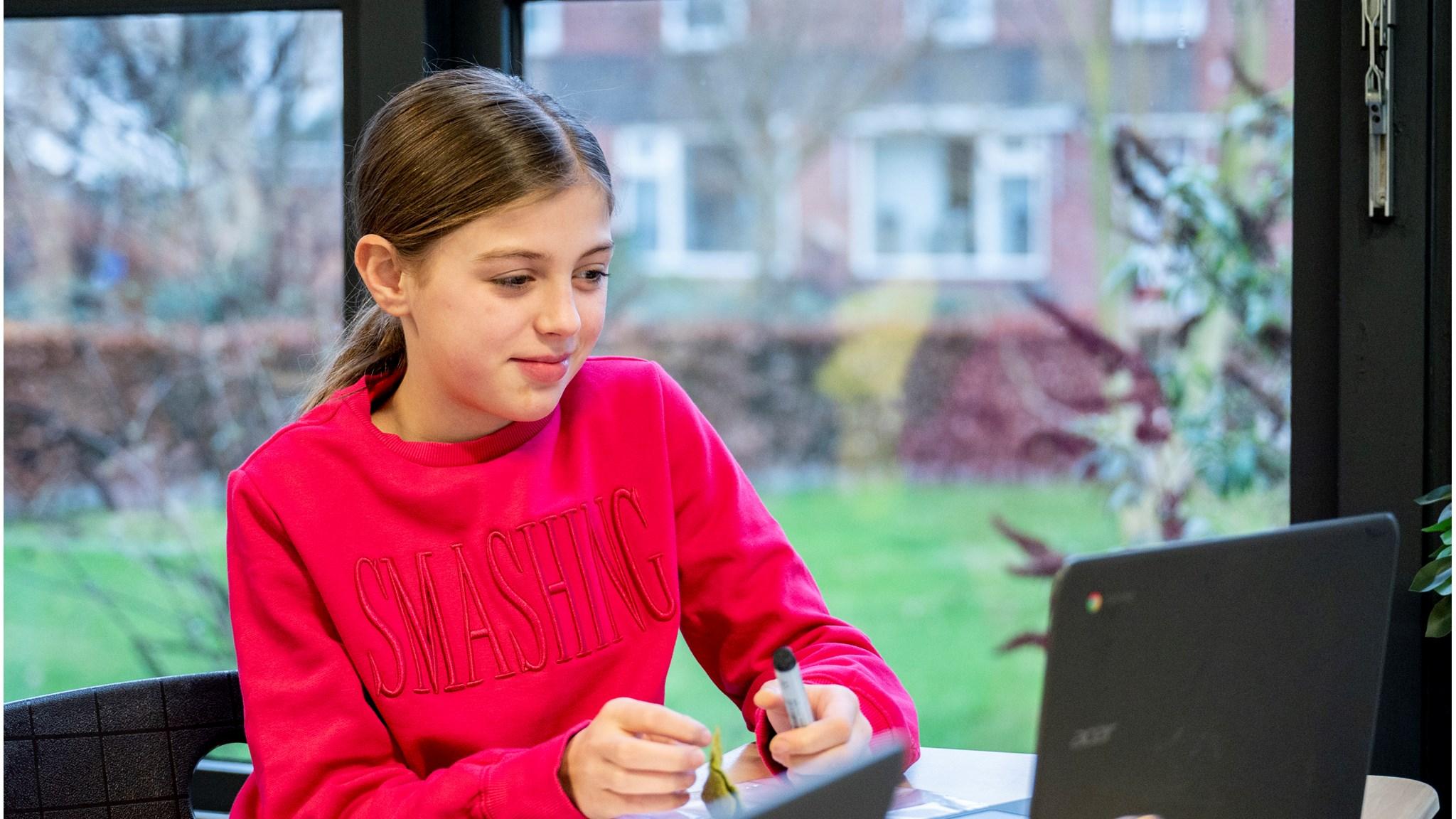 Een leerling van Openbare Basisschool De Westhoek in 2e Exloërmond die geconcentreerd werkt aan de laptop.