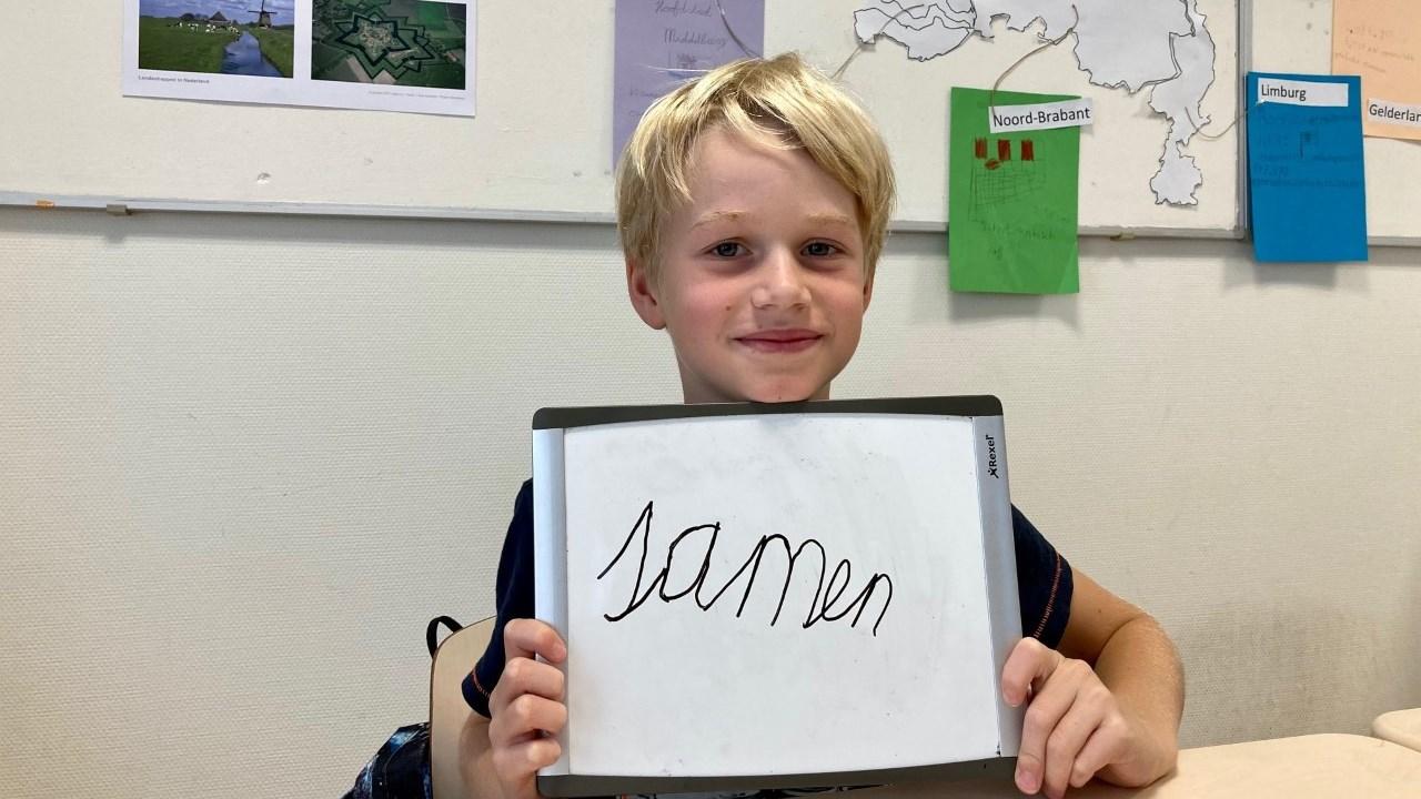 Een leerling van Openbare Daltonschool deBuut in Soest houdt een bord omhoog met het woord "samen". Een leerling van Openbare Daltonschool deBuut in Soest houdt een bord omhoog met het woord "samen".