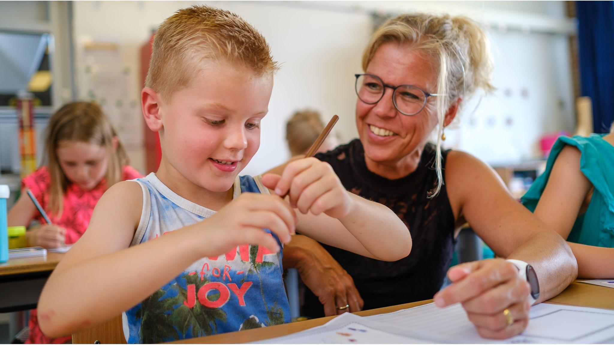 Een leerling van PCBO Prinses Juliana in Lieren werkt enthousiast samen met een lerares in de klas. Een leerling van PCBO Prinses Juliana in Lieren werkt enthousiast samen met een lerares in de klas.