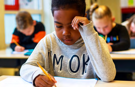 Een leerling van School Paulus in Enschede concentreert zich tijdens het schrijven. Een leerling van School Paulus in Enschede concentreert zich tijdens het schrijven.