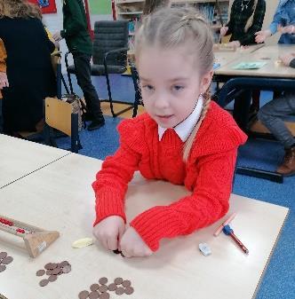 Een leerling van Stichting voor basisonderwijs op GG in Sint Philipsland is bezig met het tellen van munten aan een tafel.