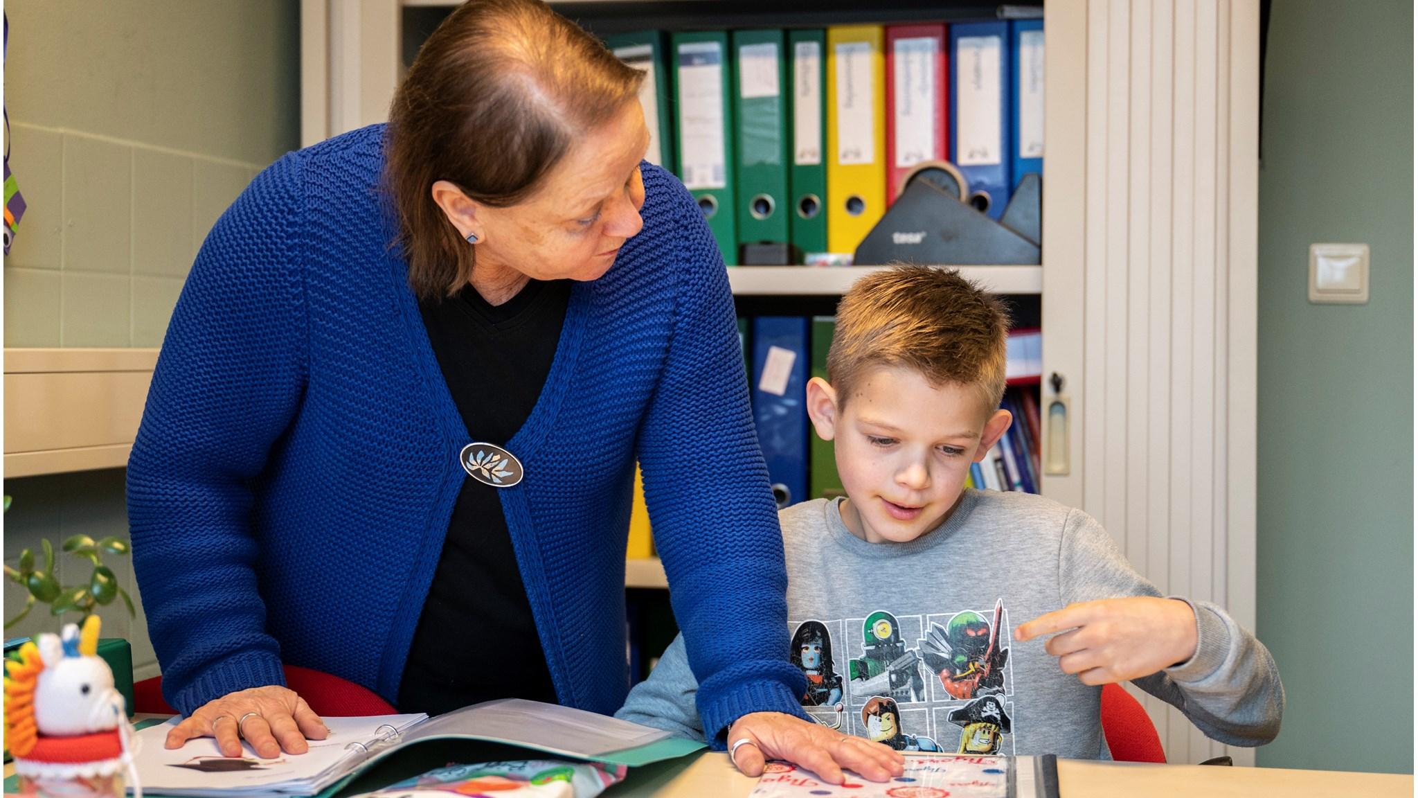 Een leerling werkt met een leraar aan een opdrachtenboek in Openbare basisschool School 75 in Nieuw-Buinen. Een leerling werkt met een leraar aan een opdrachtenboek in Openbare basisschool School 75 in Nieuw-Buinen.
