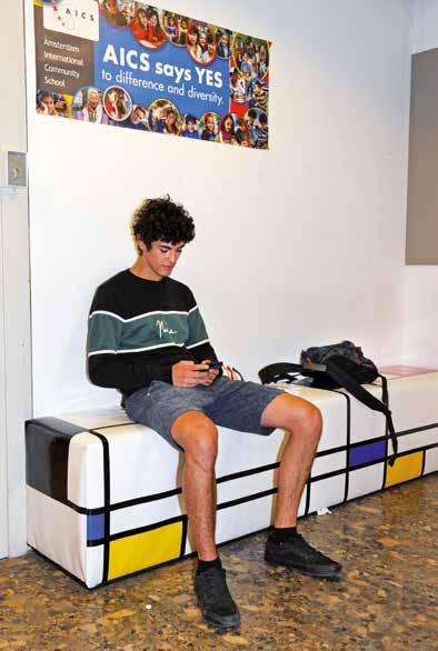 Een leerling zit op een bank in de Amsterdam International Community School (AICS), waar diversiteit en verschillen worden gevierd. Een leerling zit op een bank in de Amsterdam International Community School (AICS), waar diversiteit en verschillen worden gevierd.