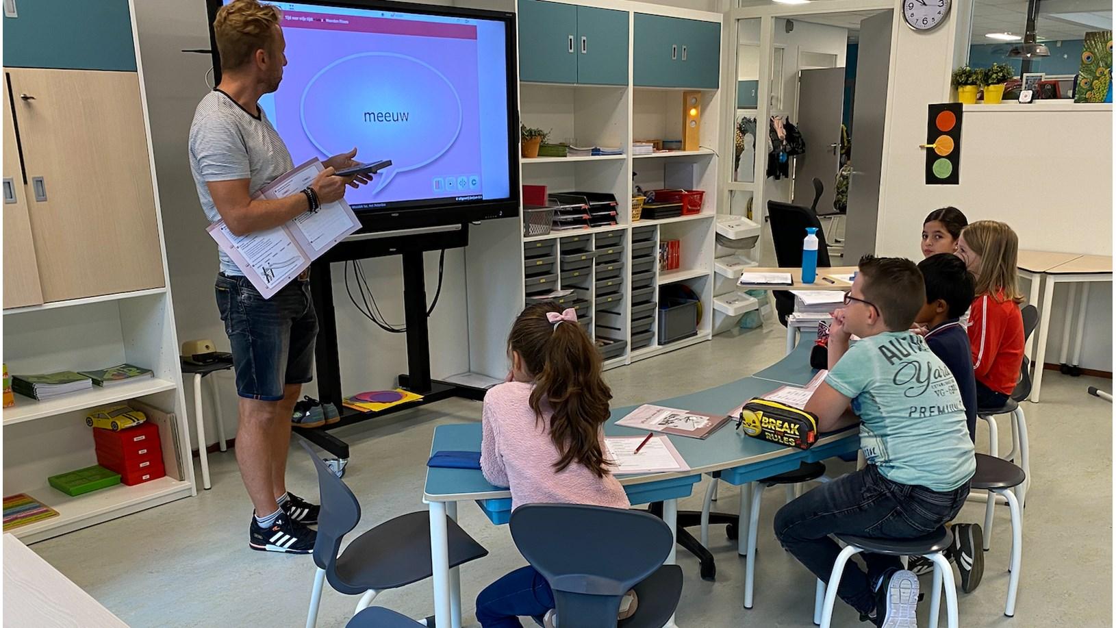 Een leraar geeft les aan kinderen in het klaslokaal van WereldKidz Mozaïek Petenbos in Veenendaal. Een leraar geeft les aan kinderen in het klaslokaal van WereldKidz Mozaïek Petenbos in Veenendaal.