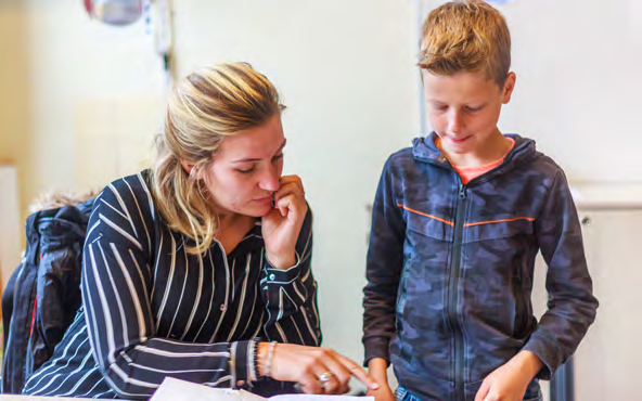 Een leraar van School Paulus in Enschede legt iets uit aan een leerling. Een leraar van School Paulus in Enschede legt iets uit aan een leerling.