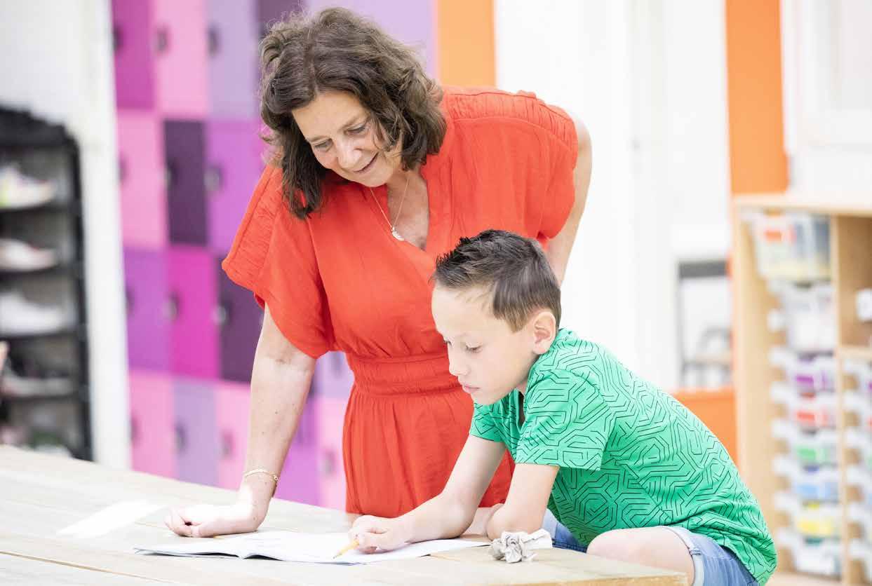 Een lerares en een leerling van Het Mozaïek in Houten bestuderen samen een boek. Een lerares en een leerling van Het Mozaïek in Houten bestuderen samen een boek.
