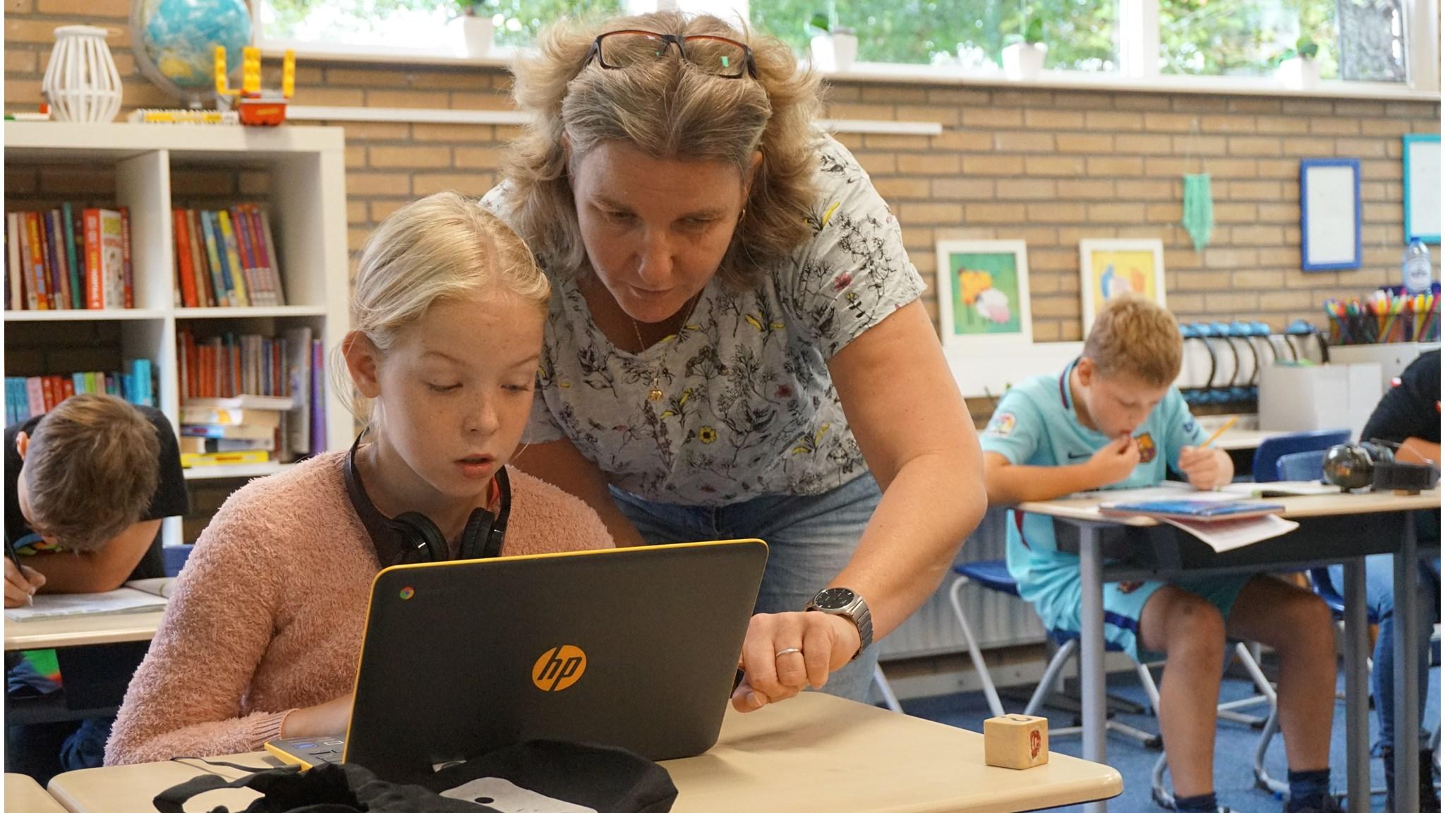 Een lerares helpt een leerling met haar laptop in de Bonnerschool in Gieten. Een lerares helpt een leerling met haar laptop in de Bonnerschool in Gieten.