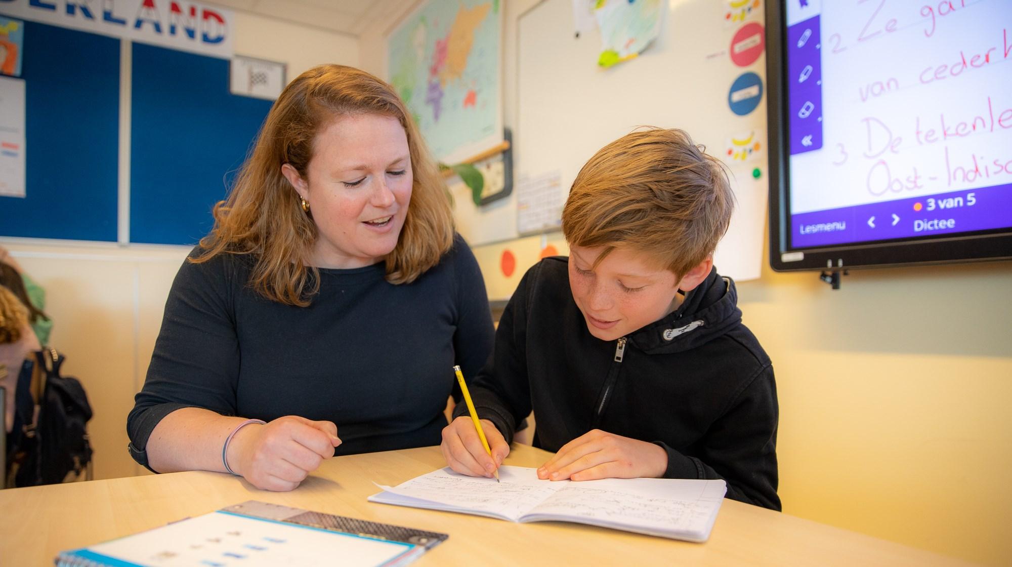 Een lerares helpt een leerling met zijn huiswerk aan De Gooise Daltonschool in Hilversum. Een lerares helpt een leerling met zijn huiswerk aan De Gooise Daltonschool in Hilversum.
