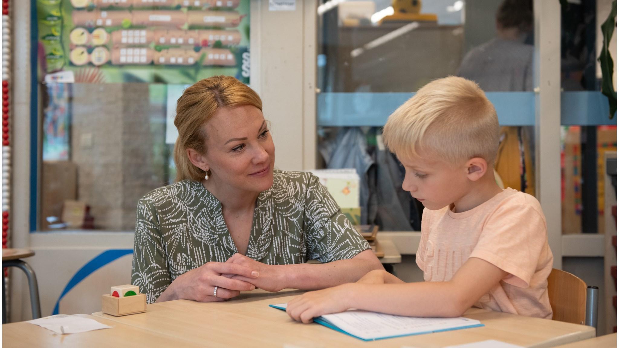 Een lerares helpt een leerling met zijn werk in De Vliegeniers in Barneveld. Een lerares helpt een leerling met zijn werk in De Vliegeniers in Barneveld.