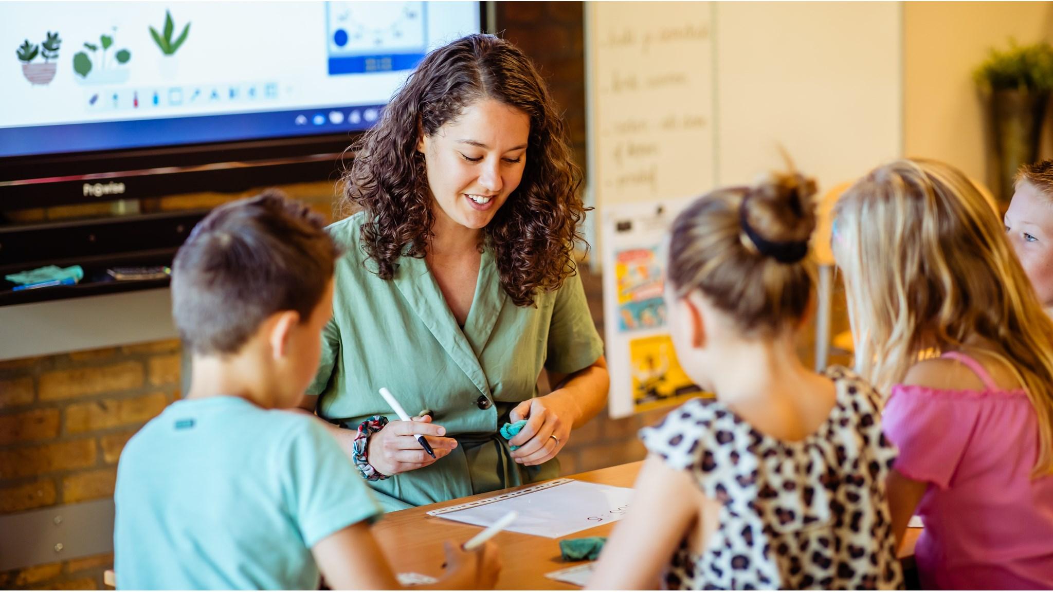Een lerares helpt kinderen met creatieve opdrachten op de Wethouder Brederodeschool in Rijswijk (Zuid-Holland). Een lerares helpt kinderen met creatieve opdrachten op de Wethouder Brederodeschool in Rijswijk (Zuid-Holland).