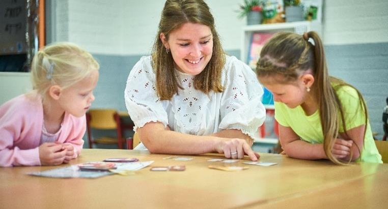Een lerares van Basisschool De Rode Schouw in Halsteren begeleidt twee leerlingen tijdens een activiteit aan tafel. Een lerares van Basisschool De Rode Schouw in Halsteren begeleidt twee leerlingen tijdens een activiteit aan tafel.