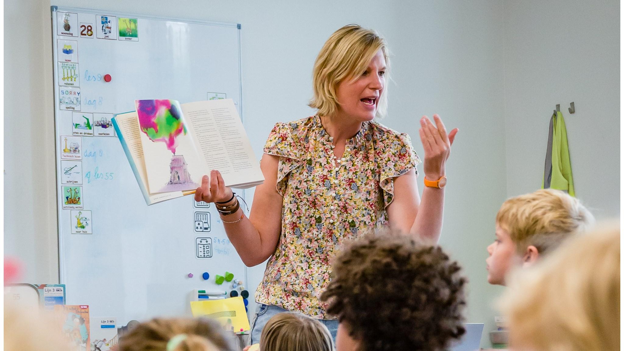 Een lerares van De Wijde Blik in Kamerik vertelt enthousiast aan een groep kinderen tijdens een les. Een lerares van De Wijde Blik in Kamerik vertelt enthousiast aan een groep kinderen tijdens een les.