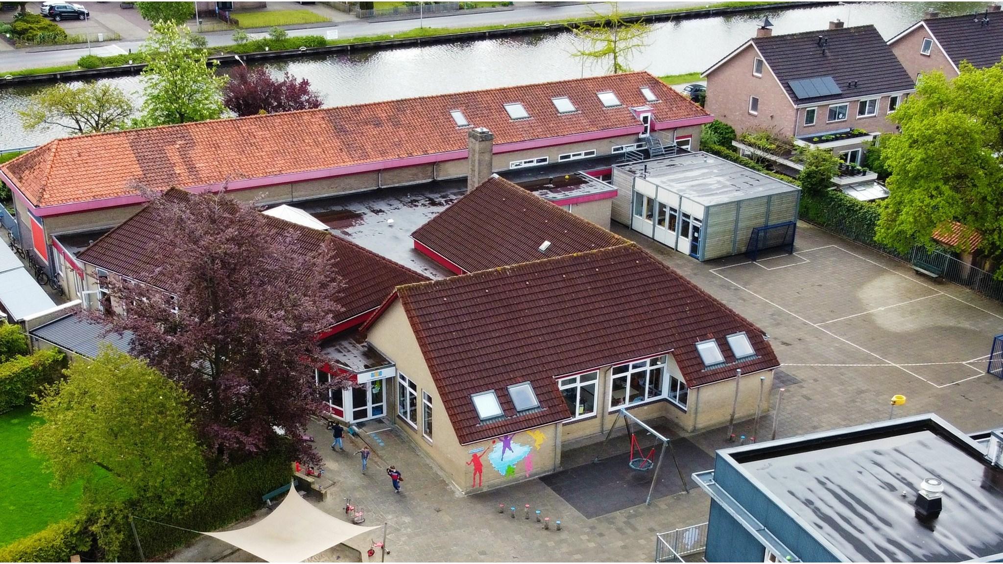 Een luchtfoto van Kindcentrum De Koningsberger in Bergentheim met een overzicht van het schoolplein en de omliggende gebouwen. Een luchtfoto van Kindcentrum De Koningsberger in Bergentheim met een overzicht van het schoolplein en de omliggende gebouwen.
