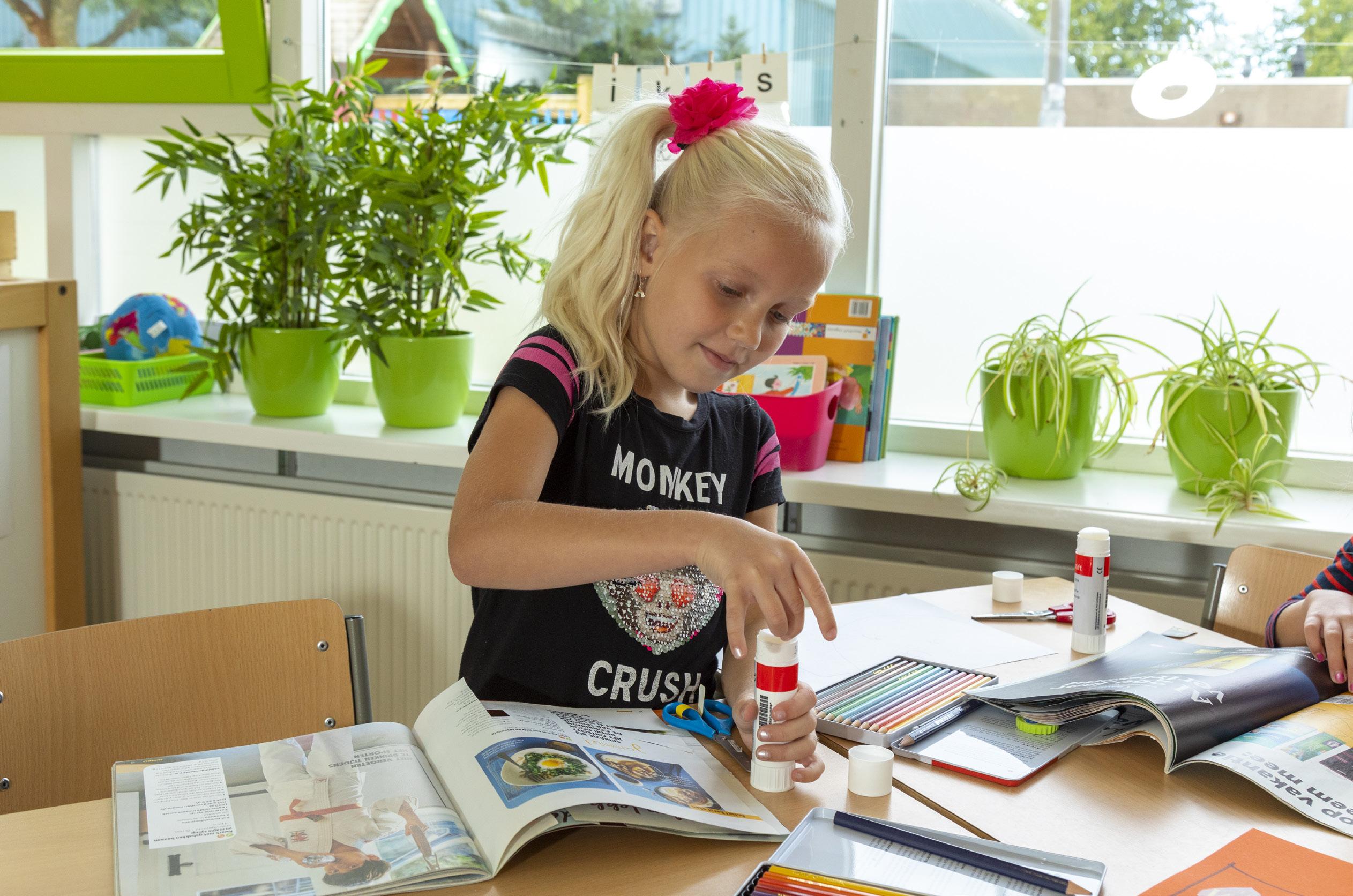 Een meisje bezig met knutselen in de klas van basisschool De Brug in IJsselstein.