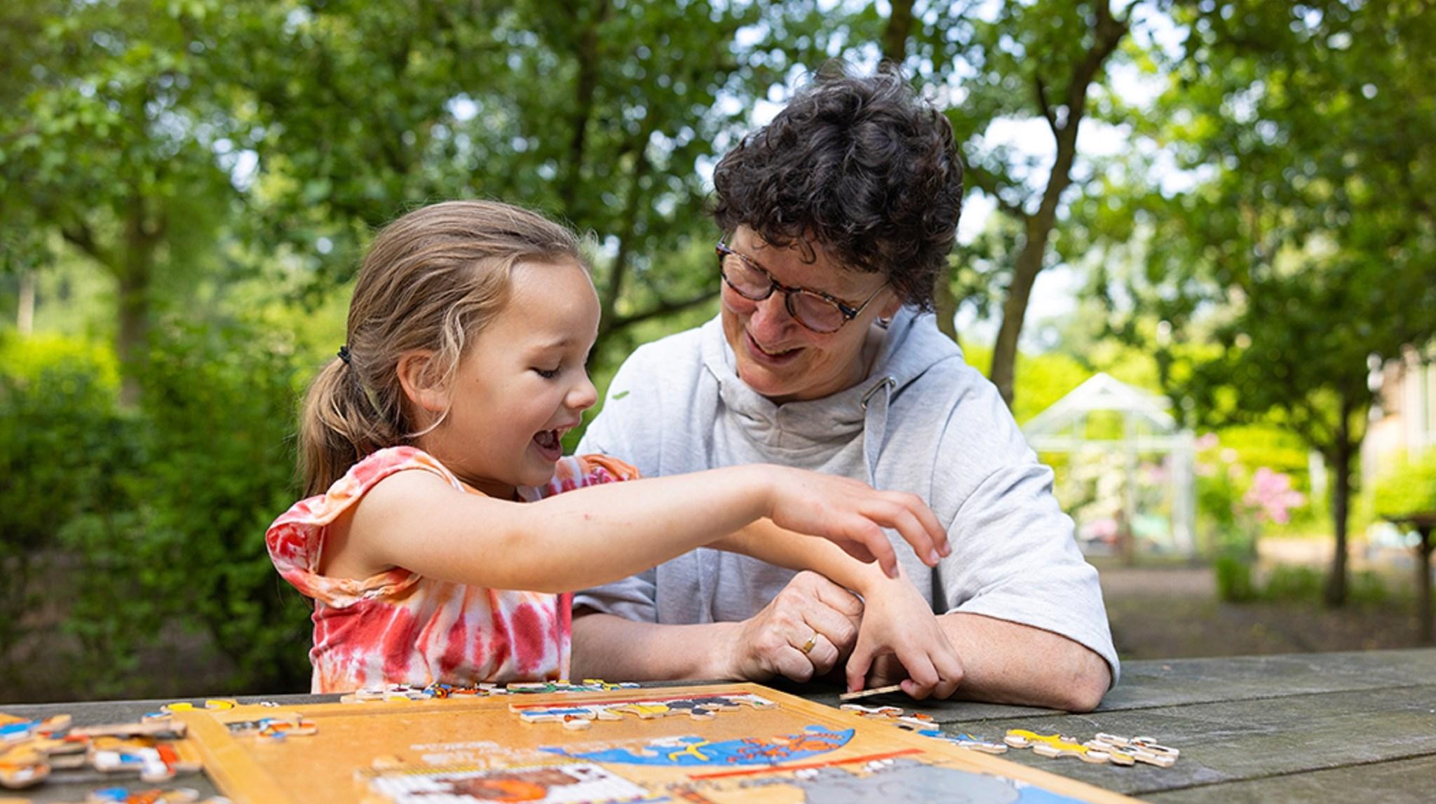 Een meisje en een volwassene genieten samen van een puzzel op het schoolplein van Montessori Sterrenschool Geerstraat in Vaassen. Een meisje en een volwassene genieten samen van een puzzel op het schoolplein van Montessori Sterrenschool Geerstraat in Vaassen.