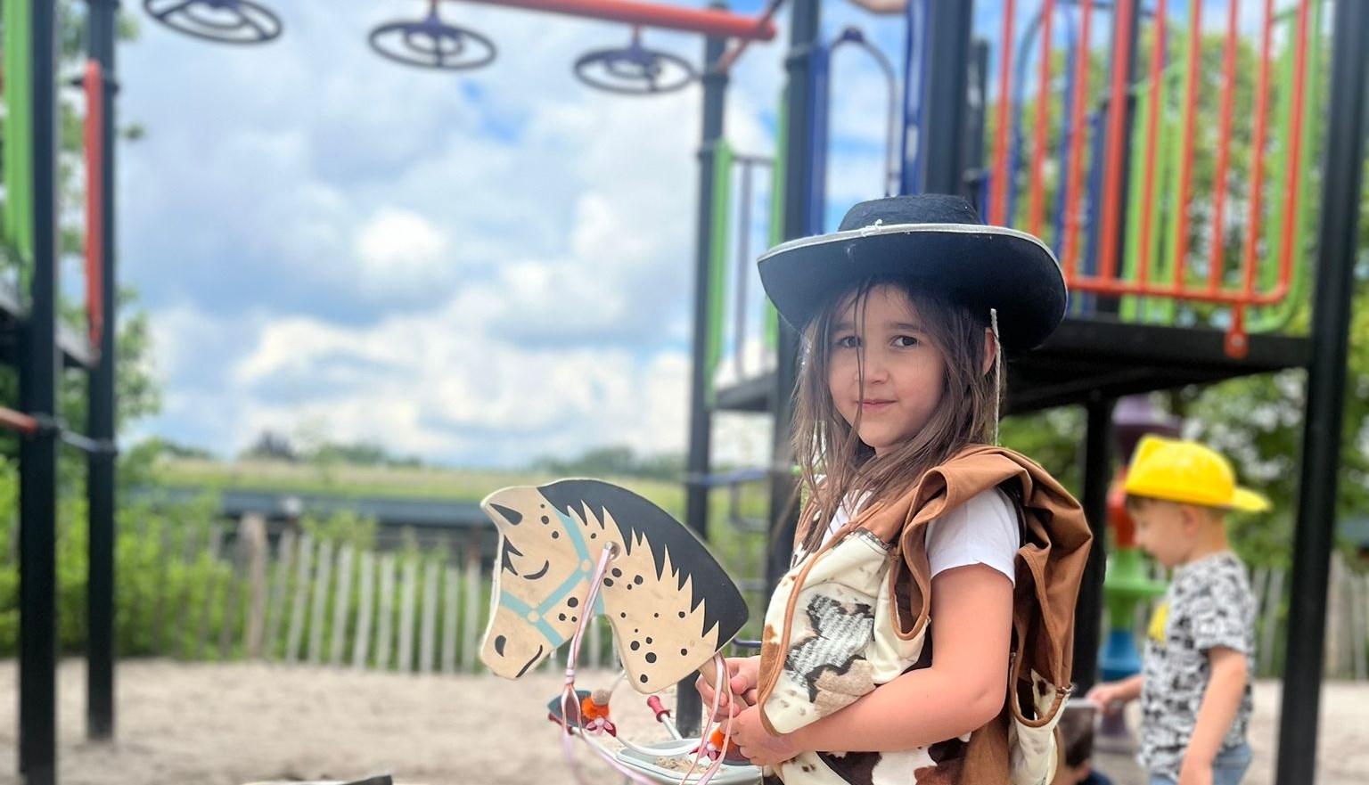 Een meisje in cowboykostuum speelt op het schoolplein van Al Ummah in Enschede.
