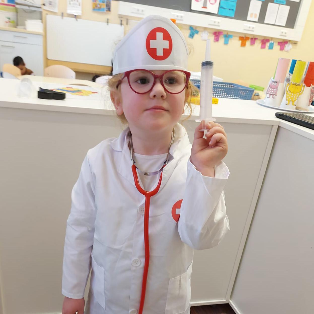 Een meisje in een doktersoutfit met een spuitje, tijdens een activiteit op OBS Het Anker in Wijk bij Duurstede.
