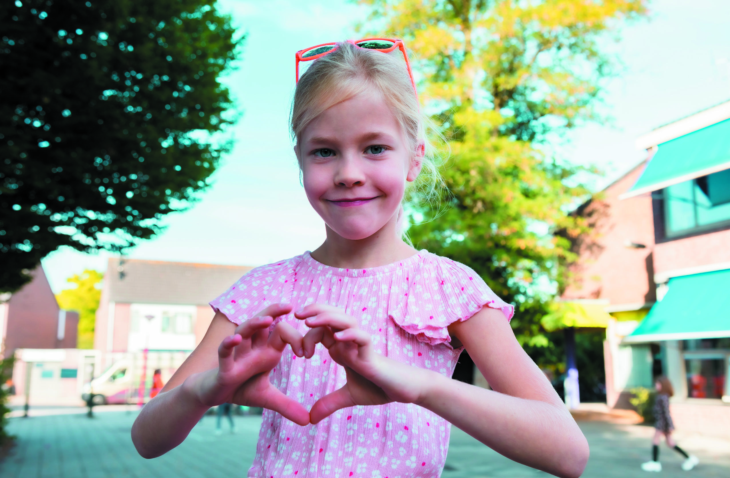 Een meisje in een schoolplein van De Trompetvogel in Nieuwegein toont een hart met haar handen. Een meisje in een schoolplein van De Trompetvogel in Nieuwegein toont een hart met haar handen.