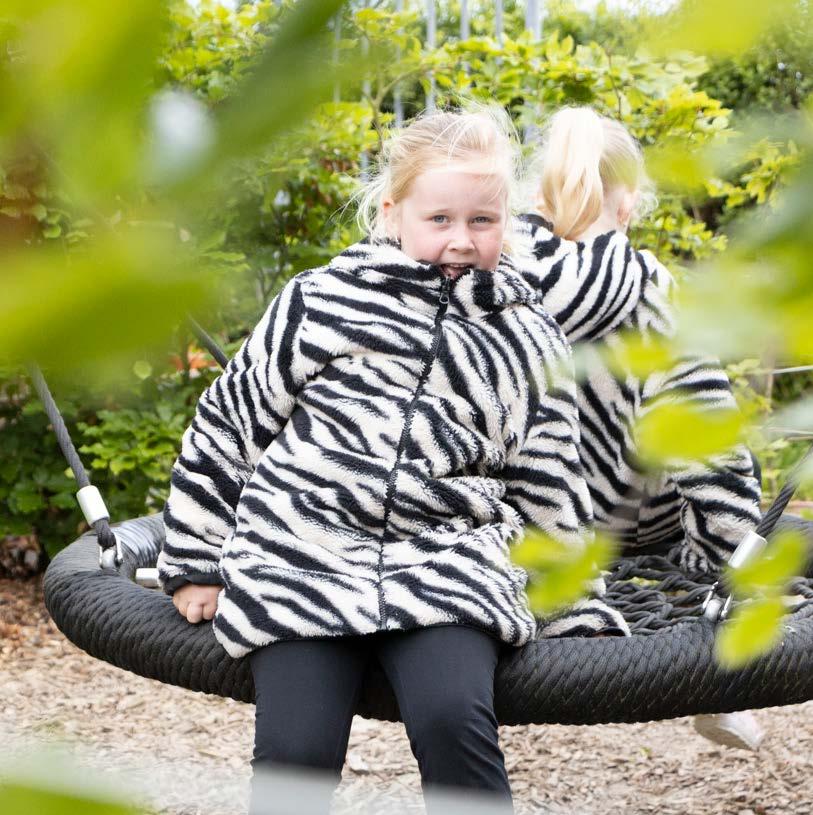 Een meisje in een zebraprint jas geniet op de schommel tijdens het schoolplein van Palmenhof in Middelburg. Een meisje in een zebraprint jas geniet op de schommel tijdens het schoolplein van Palmenhof in Middelburg.