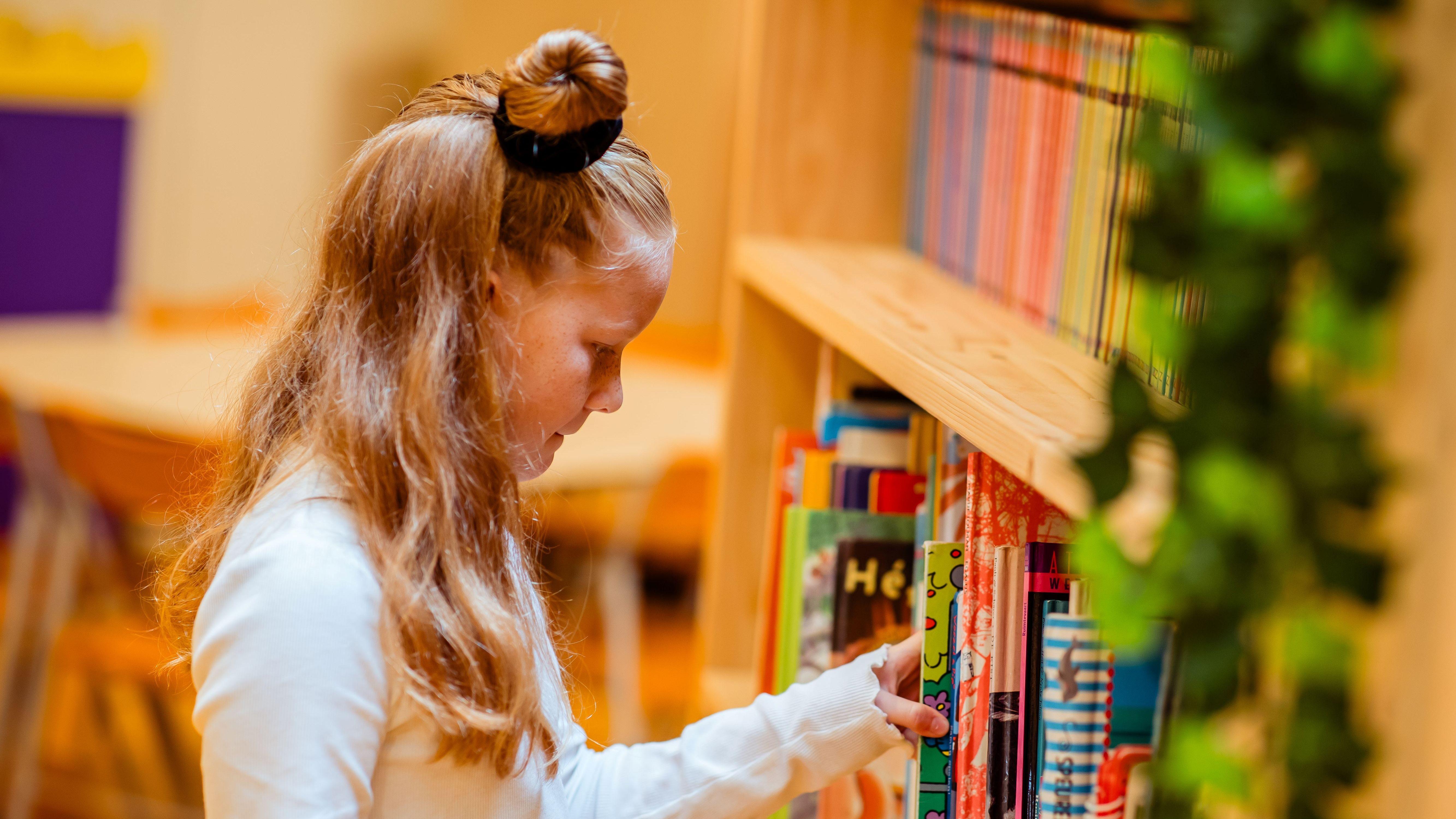 Een meisje kiest een boek uit de boekenkast op Basisschool Het Tweespan in Giessenburg. Een meisje kiest een boek uit de boekenkast op Basisschool Het Tweespan in Giessenburg.
