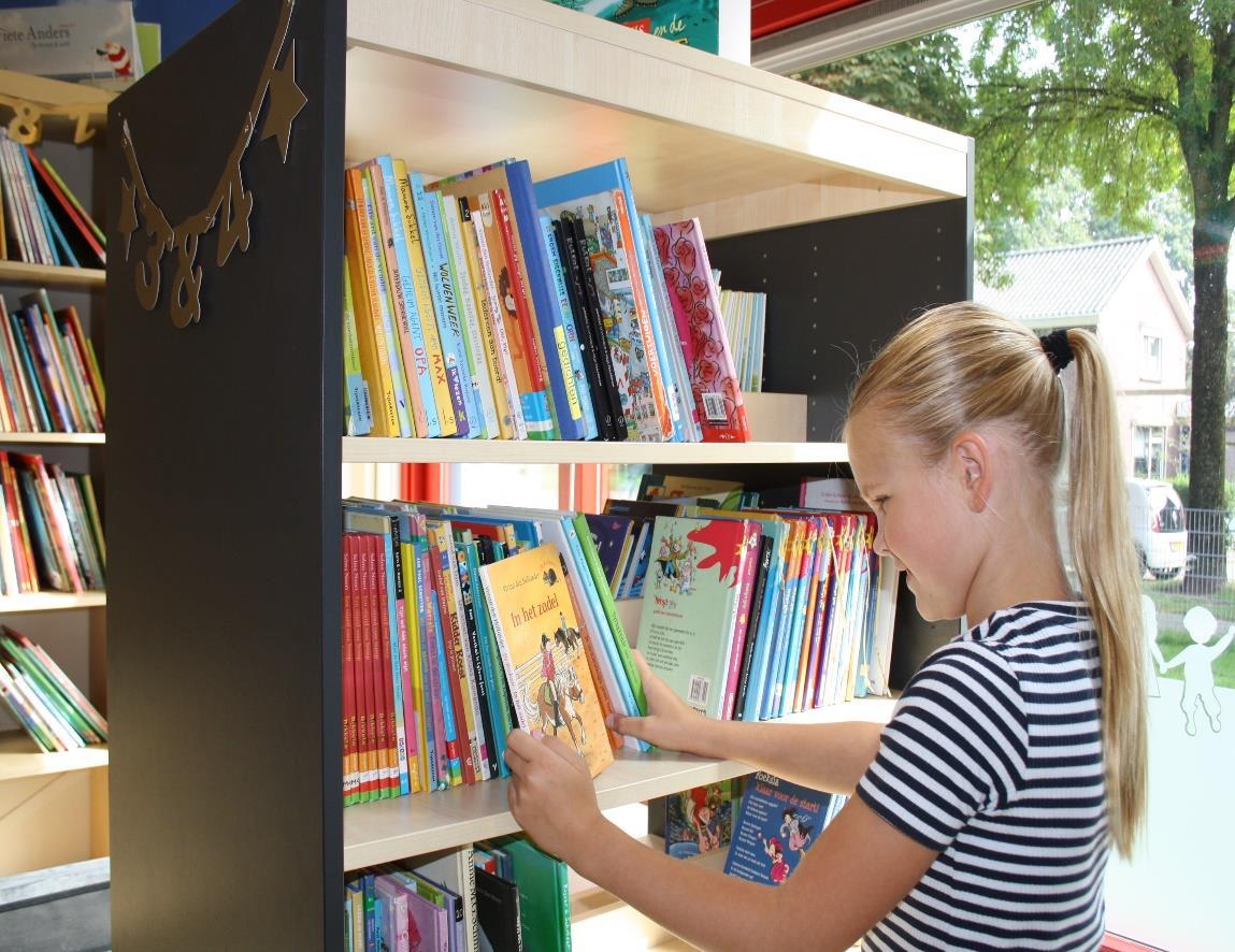 Een meisje kijkt naar boeken in de bibliotheek van Basisschool Jan Ligthart in Zelhem.