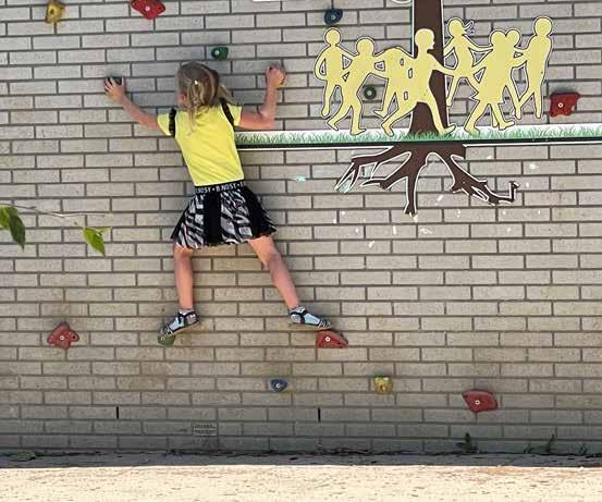 Een meisje klimt op de muur van het schoolplein van Lindenhage in Zevenaar.