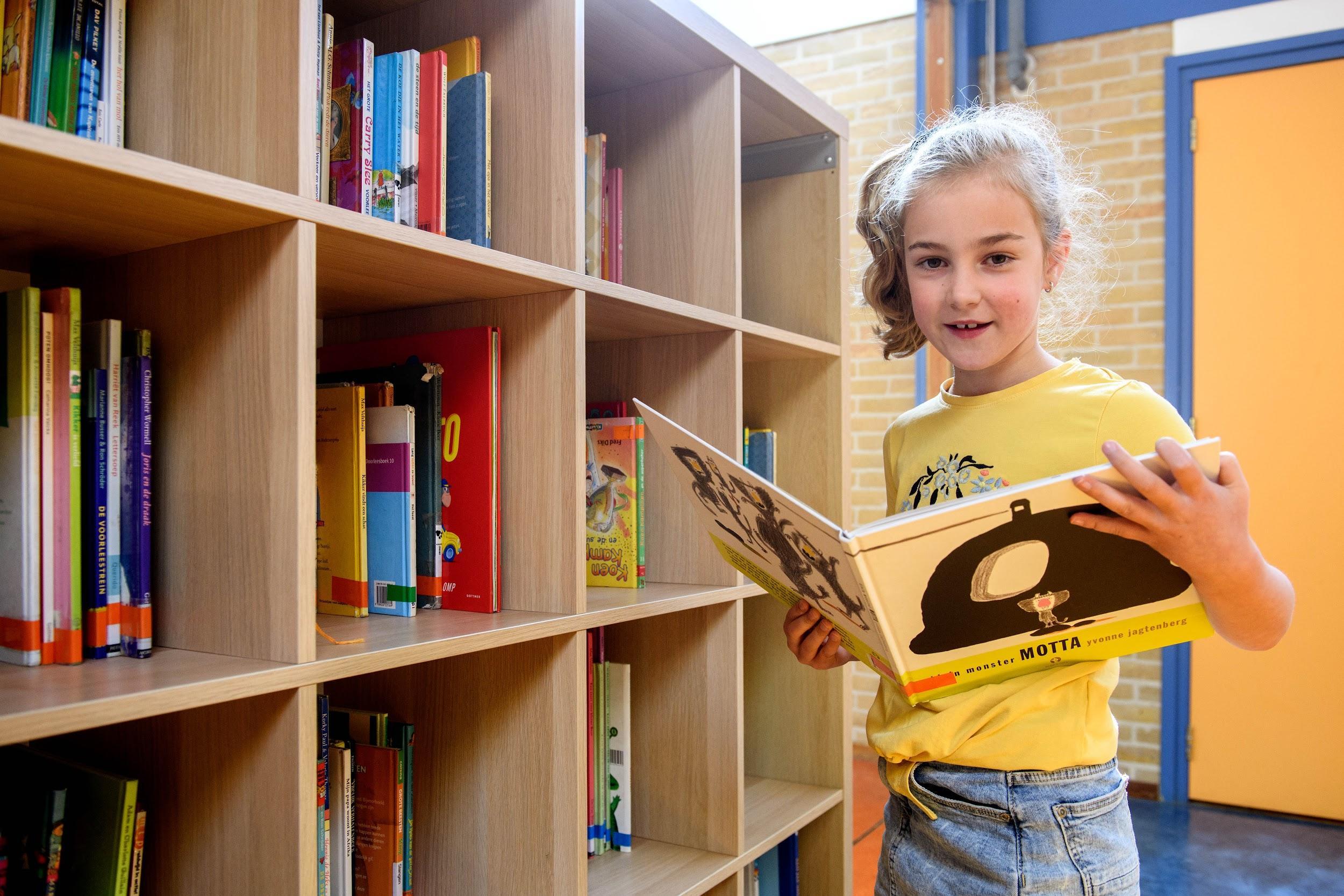 Een meisje leest een boek in de bibliotheek van de St. Nicolaasschool in Nibbixwoud. Een meisje leest een boek in de bibliotheek van de St. Nicolaasschool in Nibbixwoud.