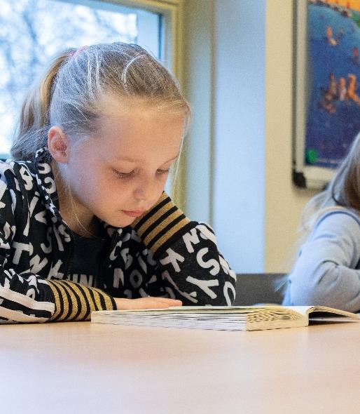 Een meisje leest geconcentreerd in de klas van OEC.Basisschool De Kubus in Zwolle. Een meisje leest geconcentreerd in de klas van OEC.Basisschool De Kubus in Zwolle.