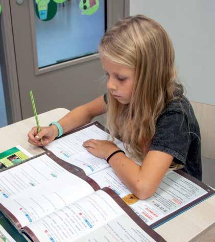 Een meisje maakt aantekeningen in een schoolboek op De Vlindertuin in Voorthuizen. Een meisje maakt aantekeningen in een schoolboek op De Vlindertuin in Voorthuizen.