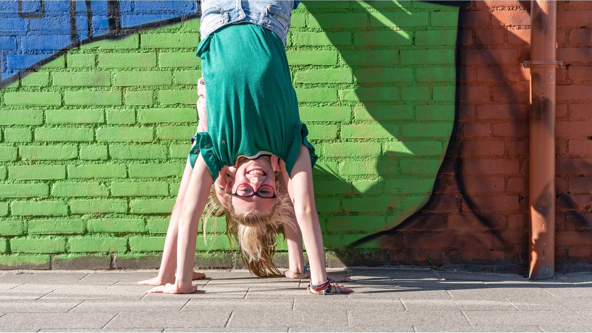 Een meisje maakt een handstand op het schoolplein van Basisschool de Maaskei in Mook. Een meisje maakt een handstand op het schoolplein van Basisschool de Maaskei in Mook.