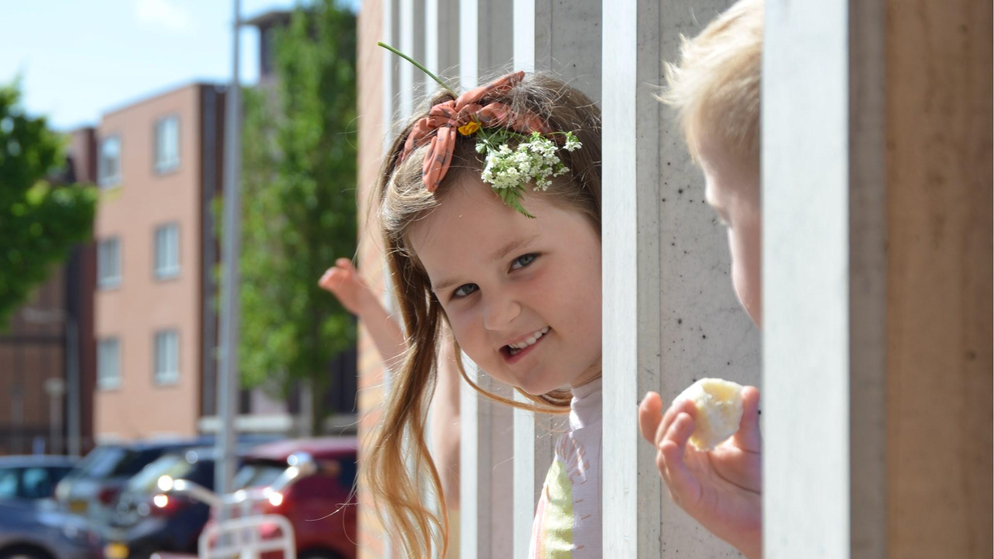 Een meisje met een bloemenkrans speelt in het schoolplein van Basisschool Juliana van Stolberg in Castricum. Een meisje met een bloemenkrans speelt in het schoolplein van Basisschool Juliana van Stolberg in Castricum.