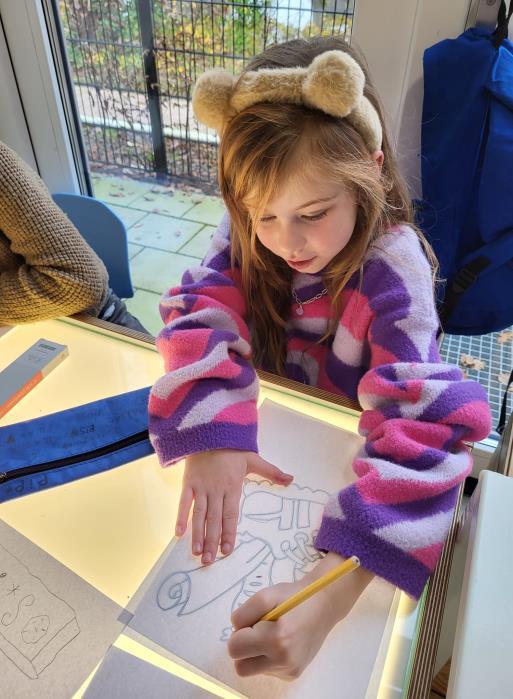 Een meisje met een schattig haarbandje tekent met een potlood op OBS De Dennenkamp in Ommen. Een meisje met een schattig haarbandje tekent met een potlood op OBS De Dennenkamp in Ommen.