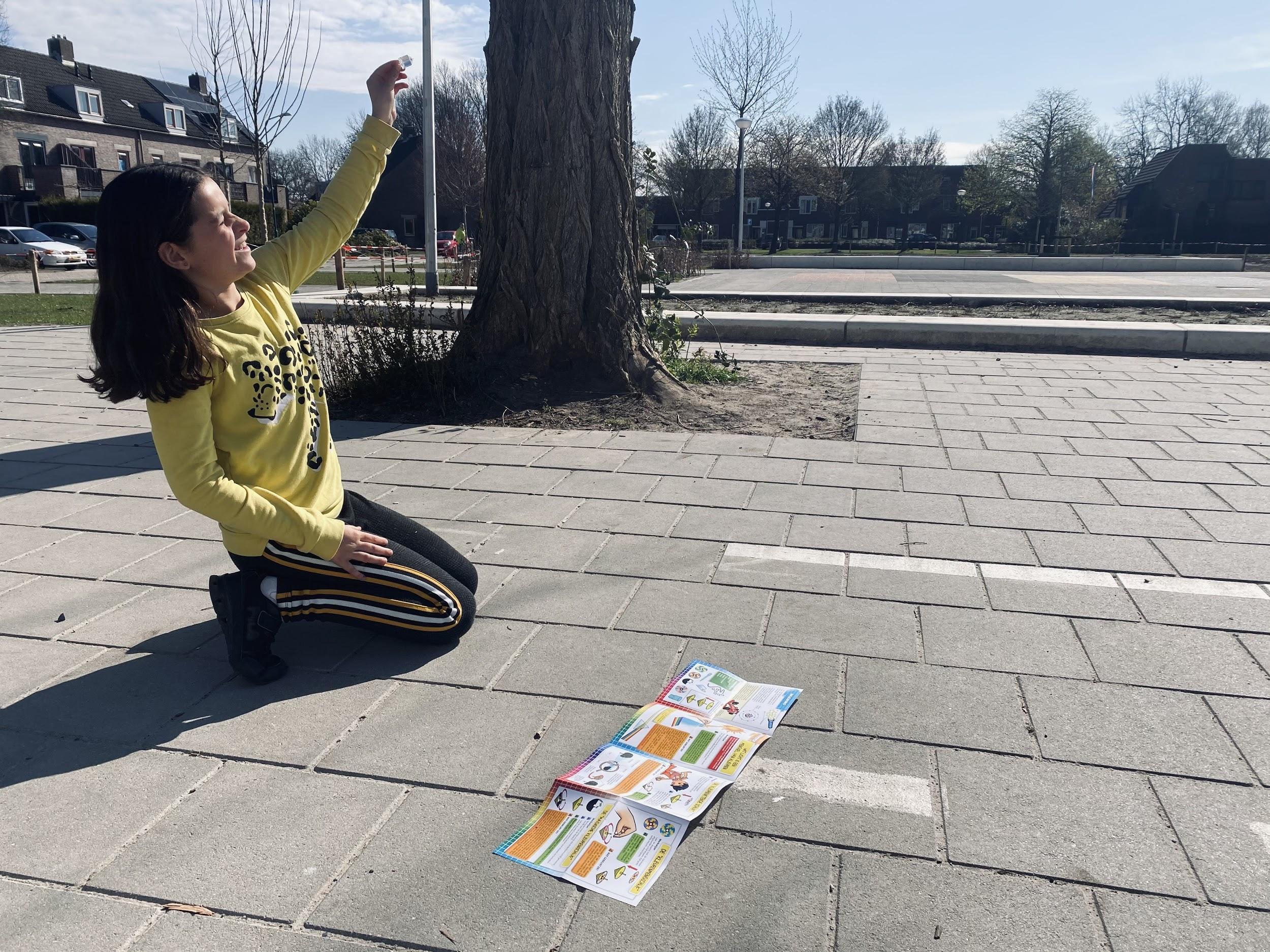 Een meisje op het schoolplein van Basisschool de Holm in Leusden, knielt terwijl ze naar een stuk papier kijkt. Een meisje op het schoolplein van Basisschool de Holm in Leusden, knielt terwijl ze naar een stuk papier kijkt.