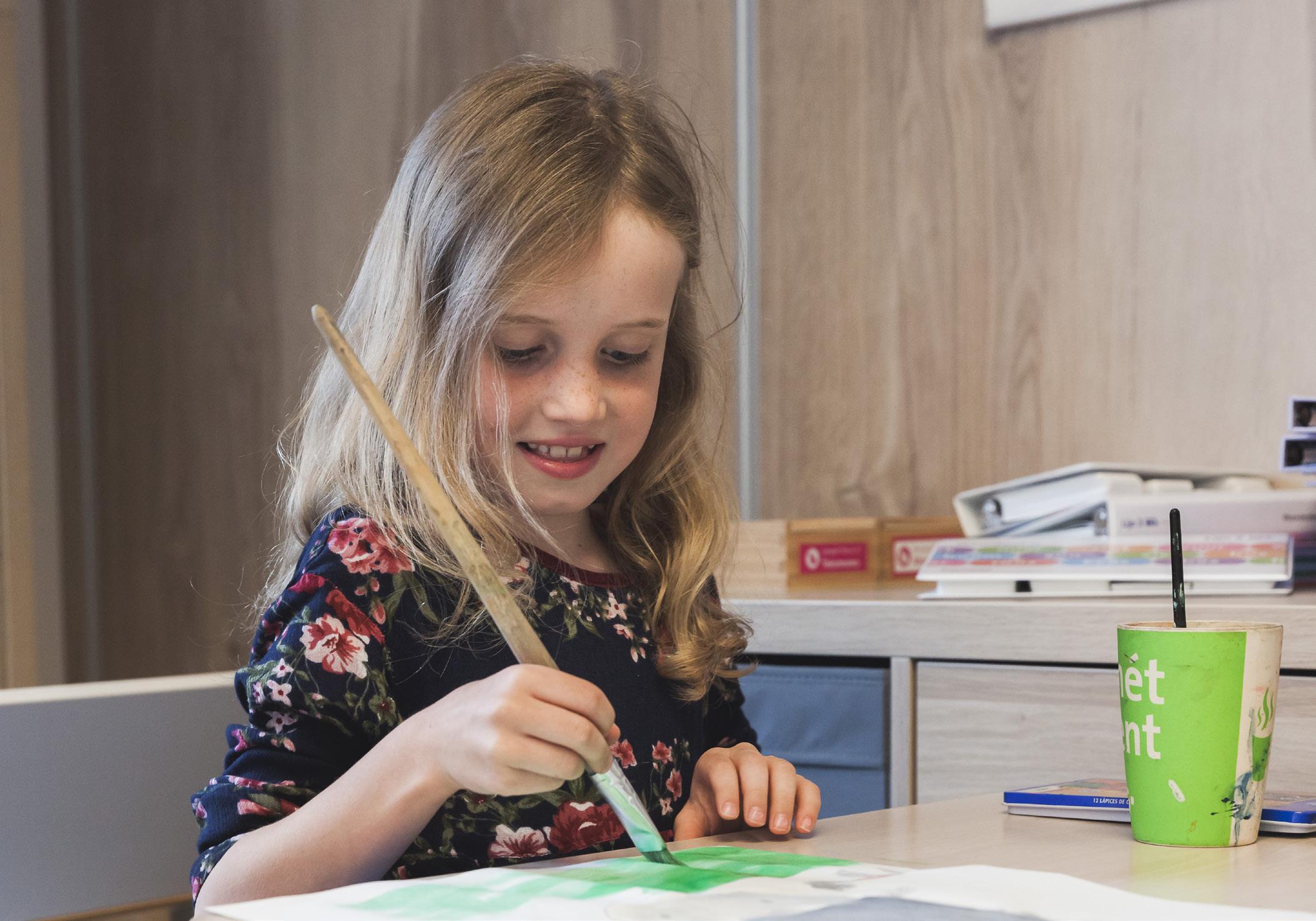 Een meisje schildert vrolijk in de klas van Openbare Basisschool De Hasselbraam in Haaren. Een meisje schildert vrolijk in de klas van Openbare Basisschool De Hasselbraam in Haaren.