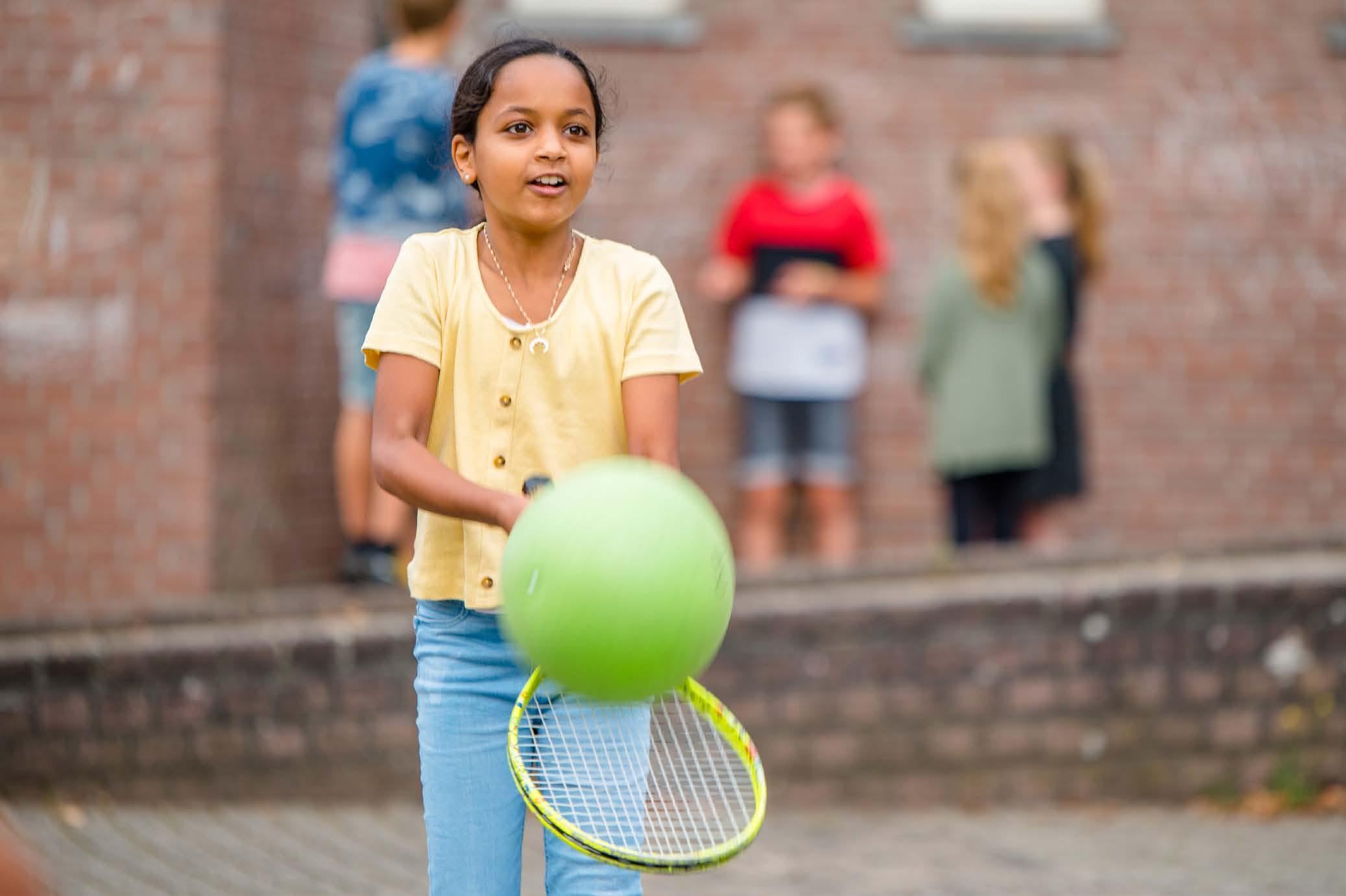 Een meisje speelt met een groene bal op het schoolplein van Chr. Basisschool Het Mozaiek in Zwolle. Een meisje speelt met een groene bal op het schoolplein van Chr. Basisschool Het Mozaiek in Zwolle.