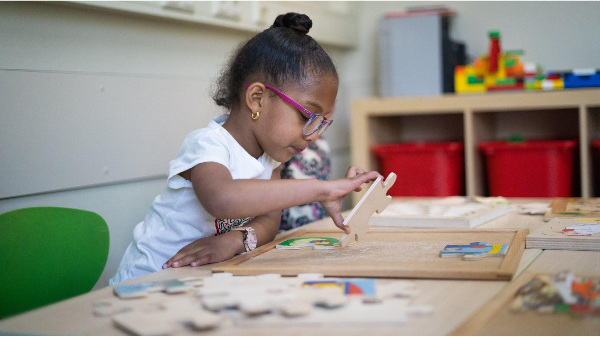 Een meisje speelt met puzzelstukken in de klas van De Kleine Wereld in Almere. Een meisje speelt met puzzelstukken in de klas van De Kleine Wereld in Almere.