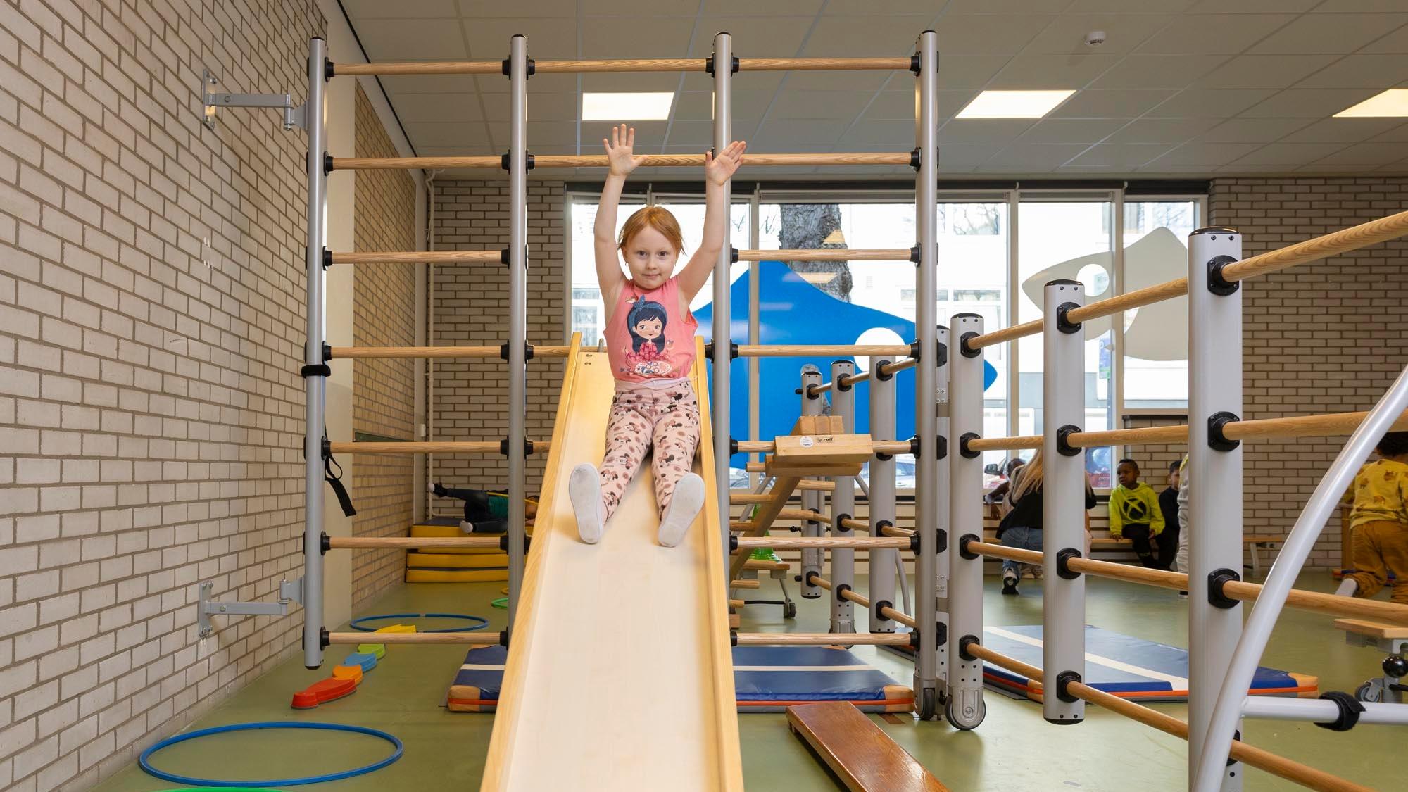 Een meisje speelt op de glijbaan in de gymzaal van basisschool Delfshaven in Rotterdam. Een meisje speelt op de glijbaan in de gymzaal van basisschool Delfshaven in Rotterdam.